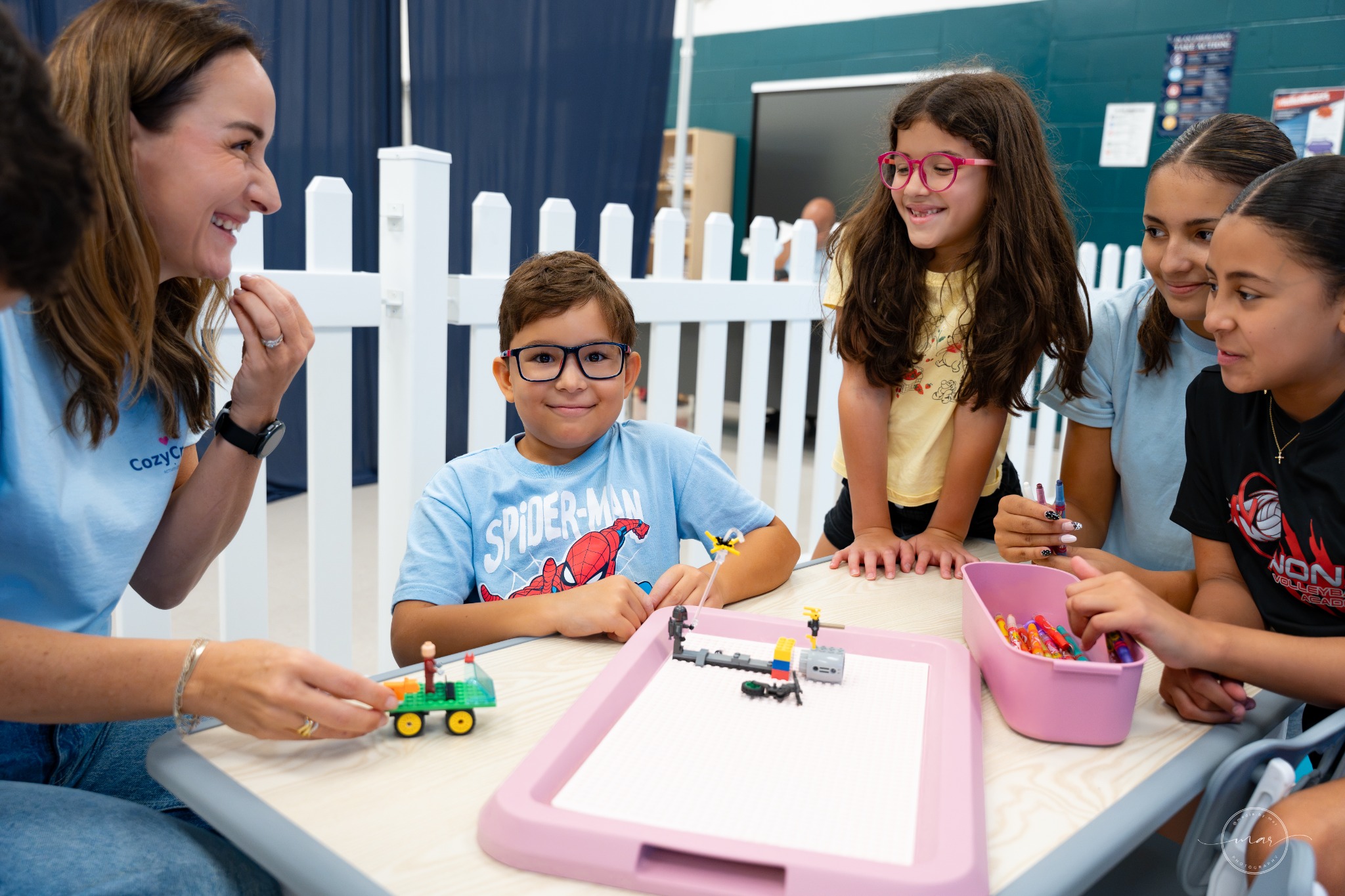 Children gathered around a CozyCrew activity table
