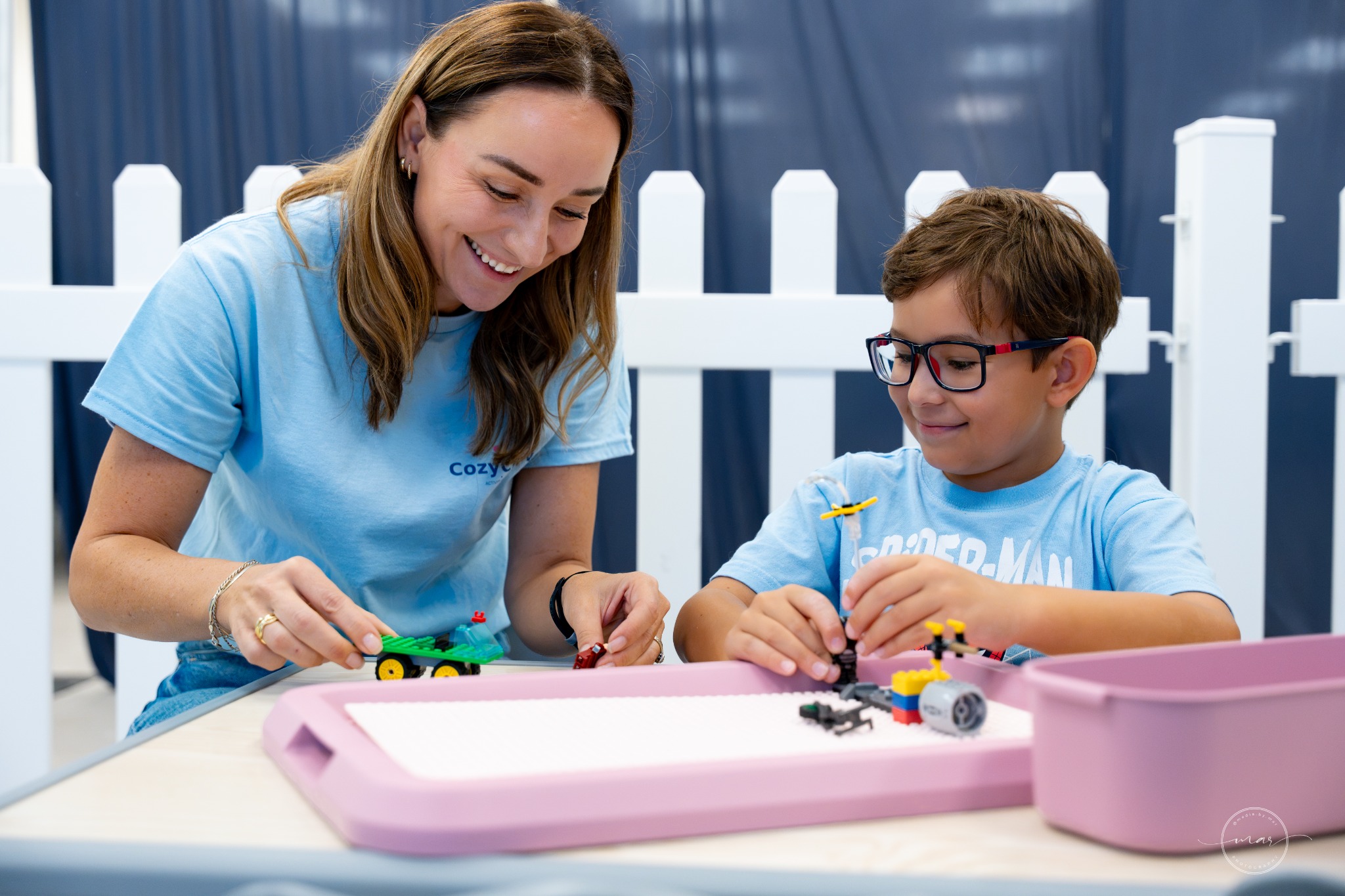 A CozyCrew team member doing a hands-on activity with a child